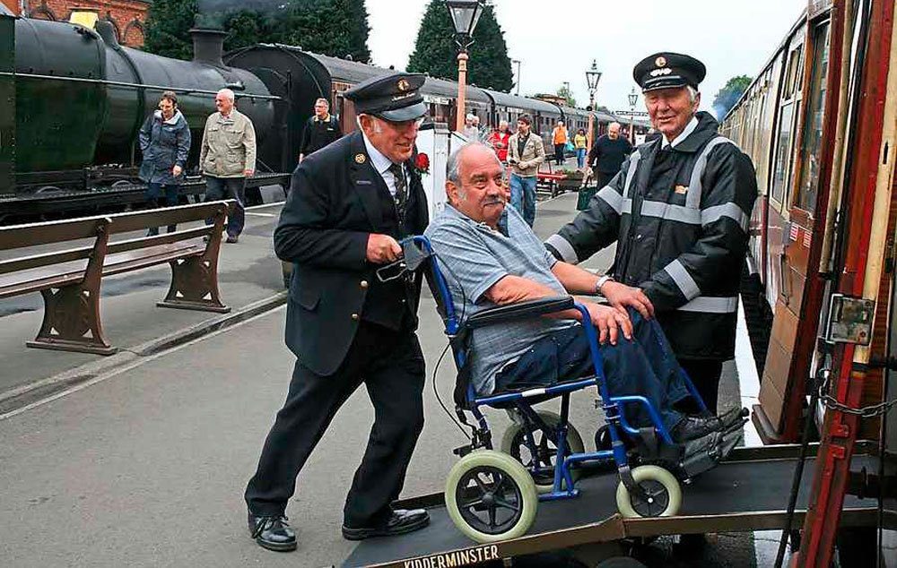 Severn Valley Railway staff help a disabled passenger onto one of their trains