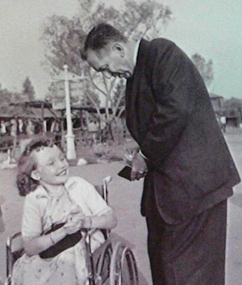 Disney - Walt signs an autograph book for a young guest. Photo part of Disney's Guest with Disabilities presentation.