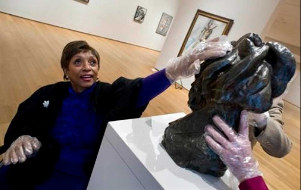 Appel runs her fingers over the face of a Picasso sculpture, a bronze head of the artist’s lover Fernande Olivier
