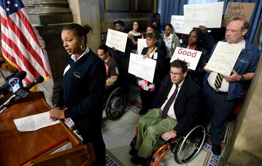 Wheelchair attendant Nikisha Watson, left, speaks during a news conference, Monday in Philadelphia. The employees of PrimeFlight transport disabled passengers throughout the airport.