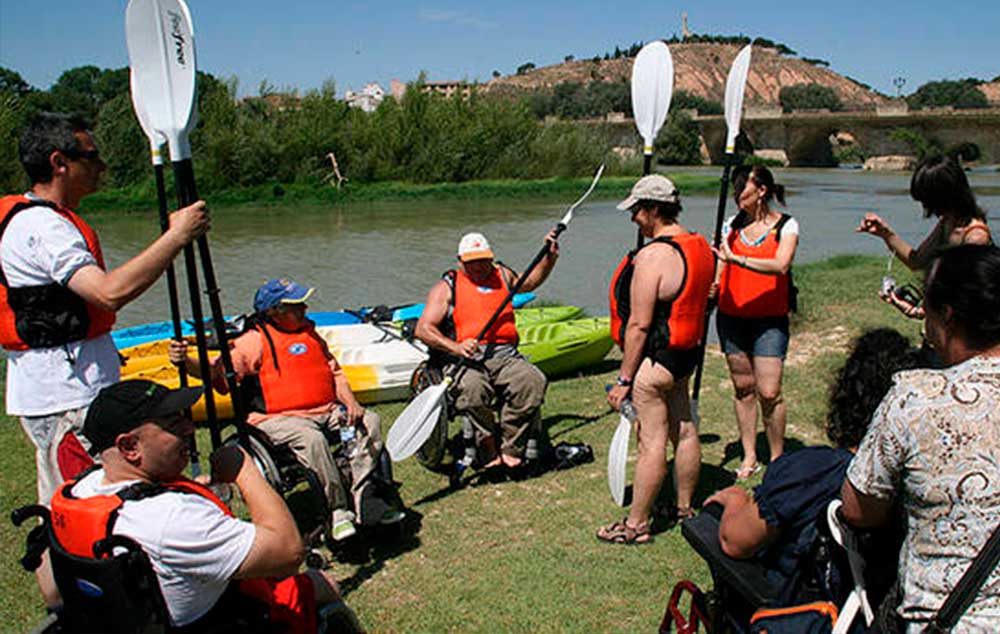 Personas con discapacidad aprenden a manejar el remo antes de montar en piragua.