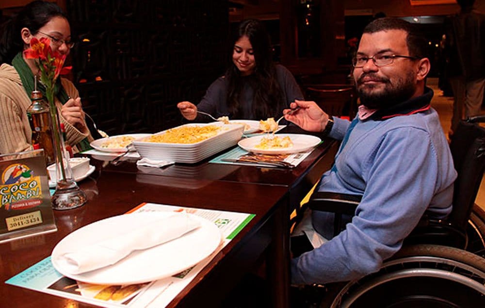 Mesas acessíveis permitem uma boa aproximação de um cadeirante. Em muitos casos a altura, largura e os pés da mesa podem ser um impedimento.