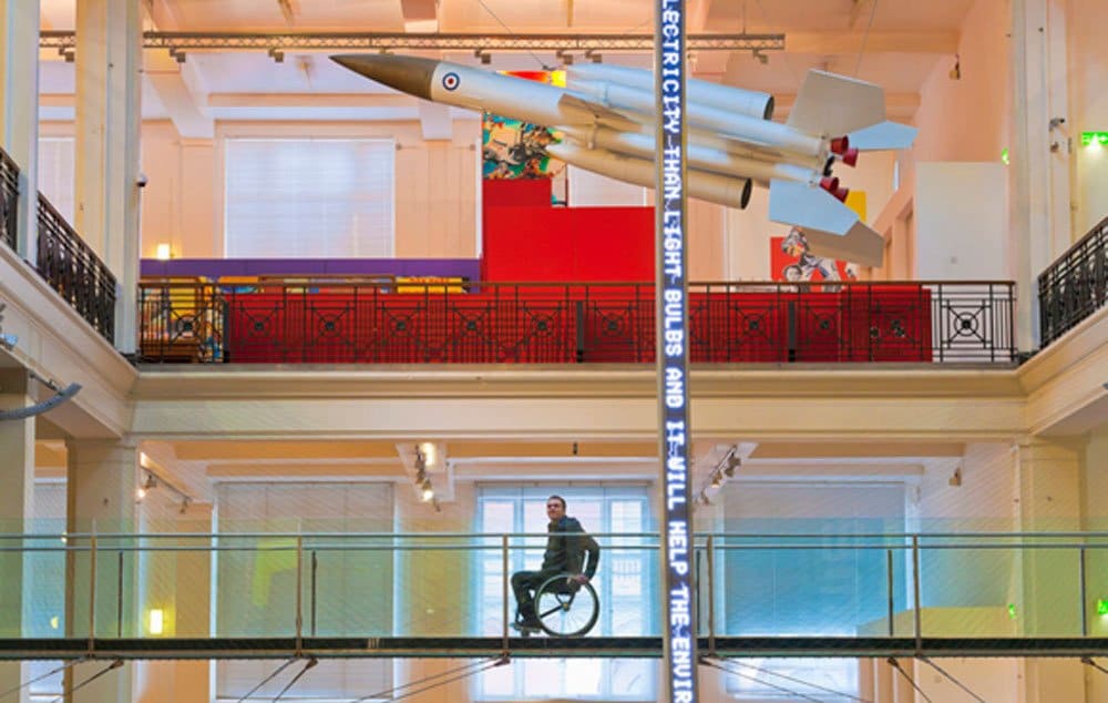 Male wheelchair user on elevated walkway at the Science Museum in London.