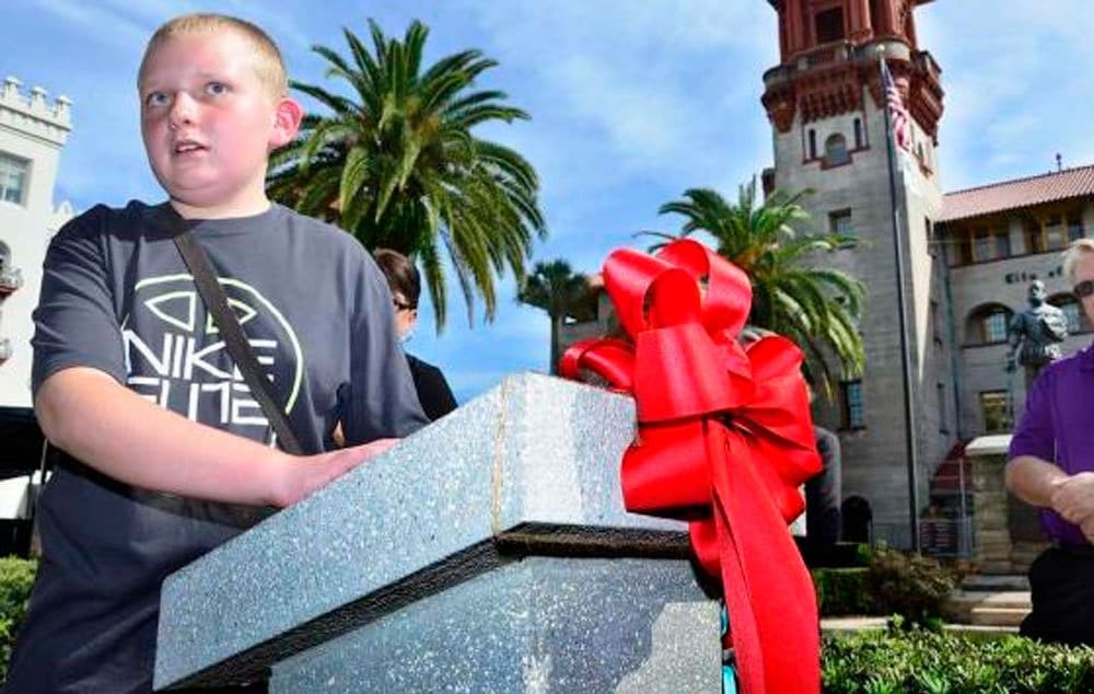 Blind student Rich Beardsley reads a Braille inscription on a marker describing the statue of Don Pedro Menendez de Aviles