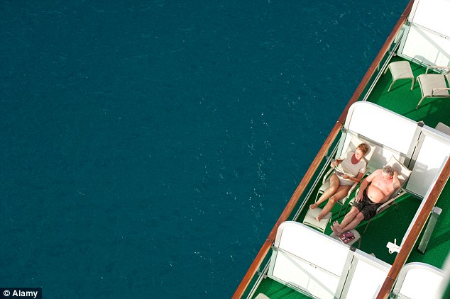 A couple relaxing on their balcony aboard a moored Azura cruise ship. The cruise offers continental breakfasts delivered to cabin balconies