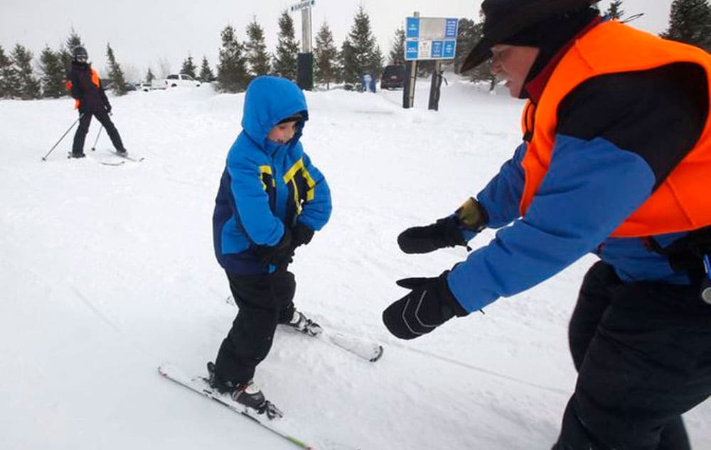 Reece Drapeau, visually impaired, gets some instruction from Steve "Cowboy" Piersch, during a ski lesson at Sundown Mountain Resort, in Dubuque