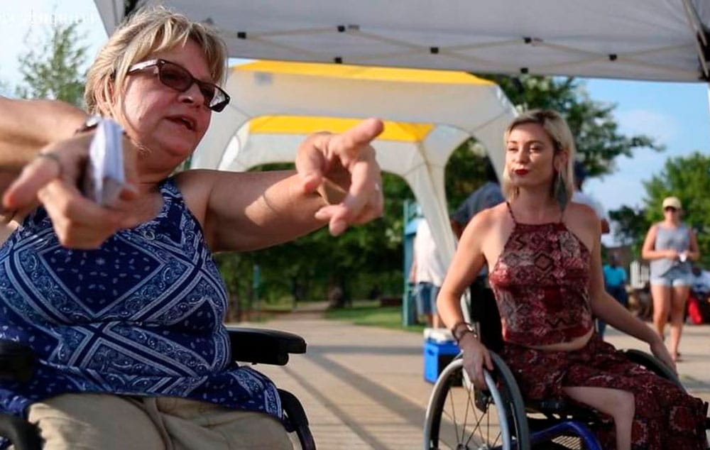 Kristine Newbold shows a wheelchair rodeo participant how to avoid barriers while riding a wheelchair at Woodruff Park in Columbus.