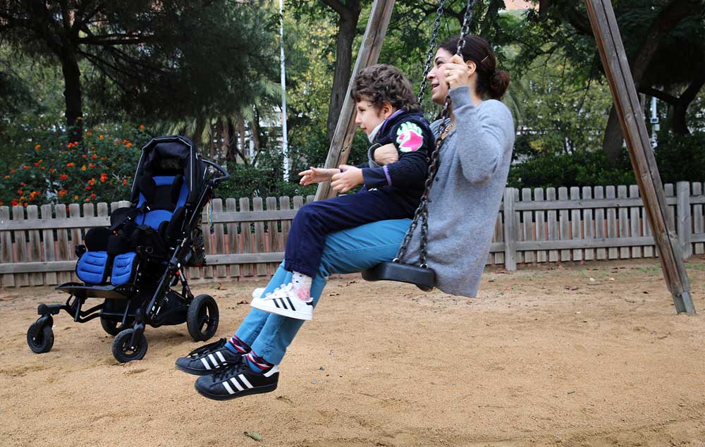 DIVERSIÓN. Marie- Pierre y su hijo Bruno se columpian en el Parc dels Voluntaris de Barcelona.