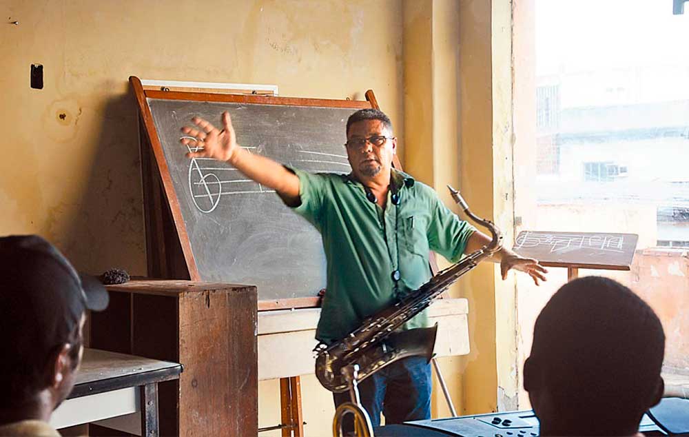 O músico e pedagogo Carlos Alberto desenvolveu um método especial para ensinar música a surdos, onde cada vibração é associada a uma nota musical