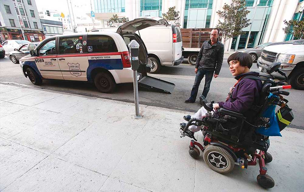 Fiona Hinze, right, is pictured with Luxor Cab paratransit driver Giovanni Favognano on Howard Street in January 2015.