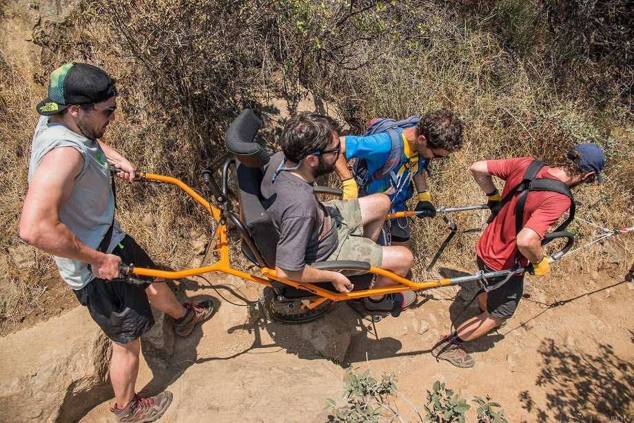 juan-pablo-pinto-left-gives-alvaro-silberstein-who-is-paralyzed-from-the-chest-down-a-hand-along-with-matias-silberstein-and-nico-spalloni-as-silberstein-rides-in-a-special-single-wheeled-wheelc